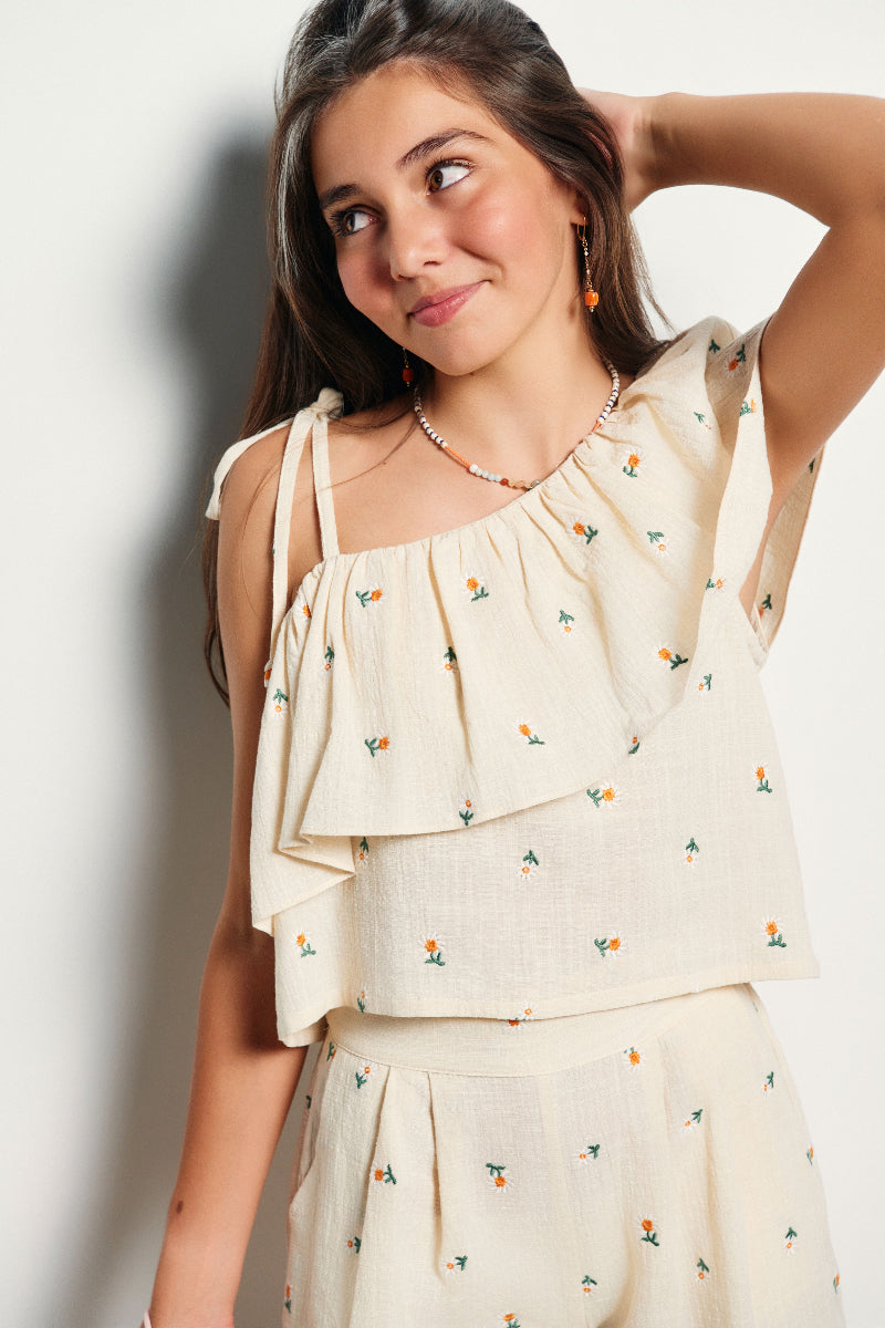 Blusa asimétrica volante bordado margaritas